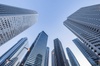 A view looking up at tall skyscrapers against a clear sky.