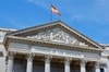 The facade of the Spanish Congress building with a flag flying above.