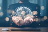 A person is holding a digital representation of the Earth with glowing connections around it.