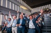 A group of cheerful men celebrating enthusiastically in an audience.