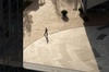 A person walking on a circular pathway in a modern urban environment.