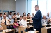 A speaker presents to an engaged audience in a classroom setting.