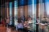 A meeting taking place in a modern office with a cityscape reflection in the windows.
