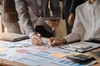 Two people collaborating on business charts and graphs at a table.