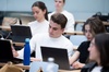 Students using laptops in a university classroom.