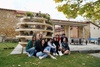 A group of people posing in front of a unique plant display structure outdoors.