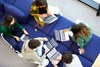 A group of students collaborating on laptops in a casual setting.