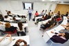 A group of students attending a presentation in a modern classroom.
