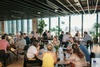 A busy dining area with people conversing and enjoying drinks at tables.