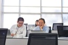 A group of students enjoying their time in a classroom with laptops.