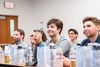 Group of people sitting in a classroom, listening attentively.