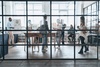 A bustling modern office space with multiple workers engaged in various activities.