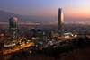 A panoramic view of a city skyline at sunset, featuring modern skyscrapers and a glowing horizon.