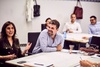 A group of people in a meeting are engaged in a lively discussion.