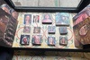 The image showcases a collection of paintings displayed on a tiled surface.