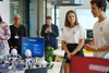 A group of students is presenting robotics projects in a modern classroom setting.