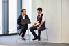 Two men are engaged in a discussion in a modern office setting.