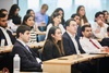 A group of young professionals attentively listening during a presentation.