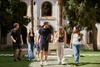 A group of young people walking together in a lush garden setting.