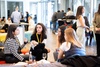 A group of women engaged in a conversation at a networking event inside a modern office space.