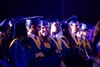 A group of graduates in caps and gowns sitting in a ceremony.