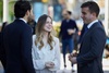 A group of three people are engaging in a conversation outdoors.