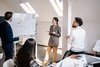 A woman doing a presentation at a whiteboard.