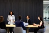 A business meeting with participants discussing a presentation at a modern conference table.