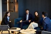 A group of four professionals engaging in a discussion in a modern office setting.