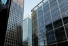 A view of modern glass buildings towering against a clear sky.