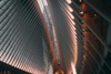 An interior view of a modern architectural structure featuring a high ceiling with symmetrical ribbed design and ambient lighting.