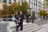 A group of professionally dressed individuals conversing and networking in an urban park setting.