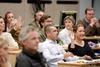 A diverse group of people engaged in a discussion at a conference.