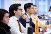 A group of students attentively listening in a classroom setting.