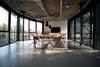 A modern conference room with large windows and a wooden table surrounded by pink chairs.