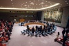 A formal meeting in the United Nations Security Council chamber with delegates standing in a circle.