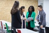 A group of professionals engaging in a discussion in a modern office space.