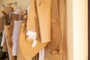 A collection of pattern papers and fabric cuttings hanging on a rack in a fashion design studio.