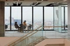 A modern office space featuring a group of people having a discussion with a city view in the background.