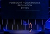 A speaker presenting on governance and ethics at an event.