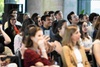 A diverse group of people smiling and engaged in a conversation during an event.