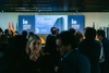 A group of people gathered at the Tech Foresight Summit 2024 event with a university backdrop.