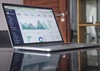 A laptop displaying financial graphs and data analytics on its screen.