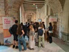 A group of people gathered at an event in a historic building with a stylish banner displaying 'IEU LABS FAIR'.