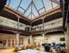 A modern open workspace featuring a lofted design with wooden beams and a glass roof.