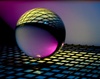 A reflective sphere resting on a grid with colorful lighting effects.