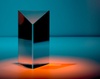 A reflective geometric object casting a soft orange glow on a blue background.
