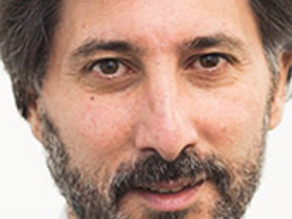 Close-up portrait of a middle-aged man with a beard and mustache, wearing a suit.