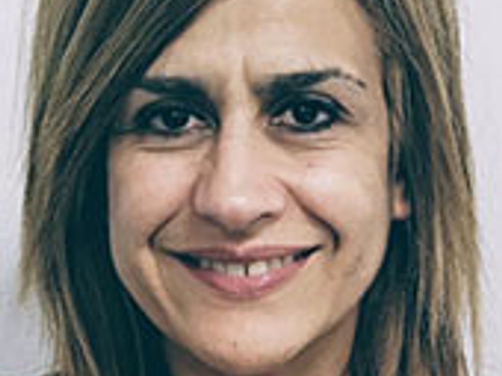 Portrait of a middle-aged woman with blond hair smiling at the camera.