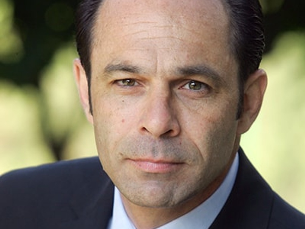 Portrait of a middle-aged man with a serious expression, wearing a suit and tie.